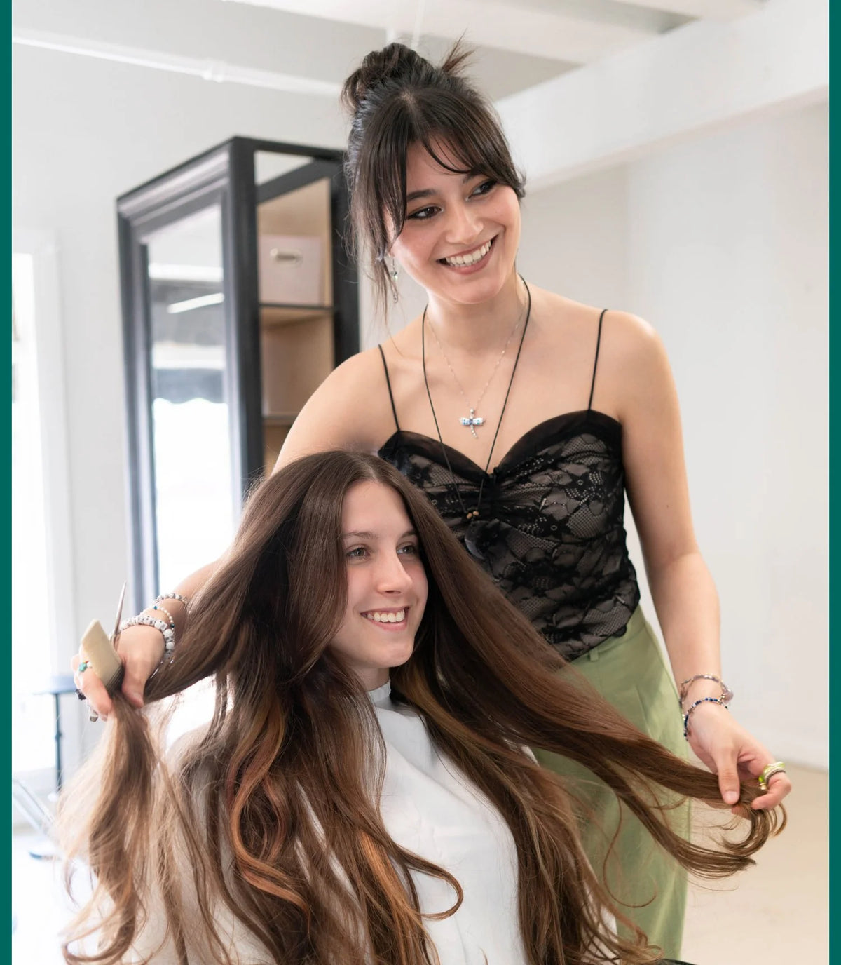 A stylist checking a guest's long, dimensional color at Zayda Hair & Apothecary, San Antonio TX