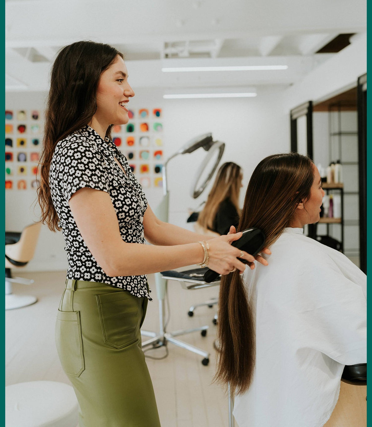 Stylist smoothing a client's long hair at Zayda Hair & Apothecary, San Antonio TX